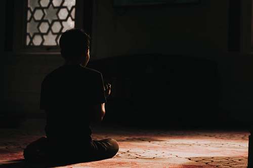 person low-light photo of man sitting on the floor kuala lumpur