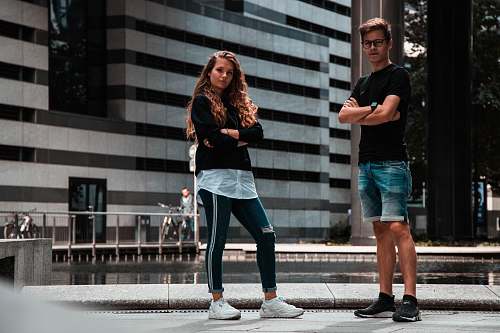 apparel man and woman standing near building clothing
