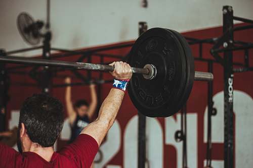 person man carrying barbell at the gym people