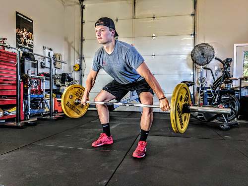 exercise man carrying yellow barbell people