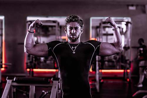 person man flexing his biceps inside gym exercise