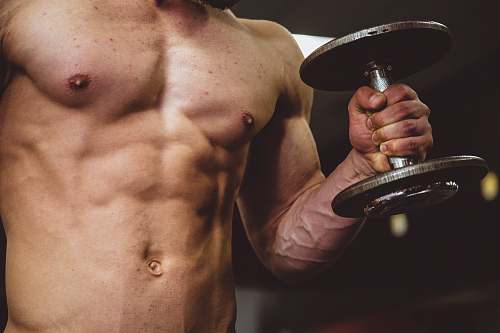 person man holding black dumbbell people
