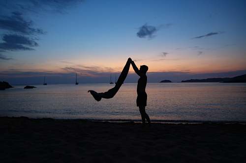 person man holding textile on seashore during day boat