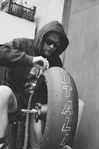 person man holding vehicle wheel black-and-white