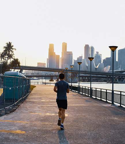 person man jogging on street during daytime shorts