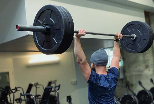 sports man lifting barbell in gym person