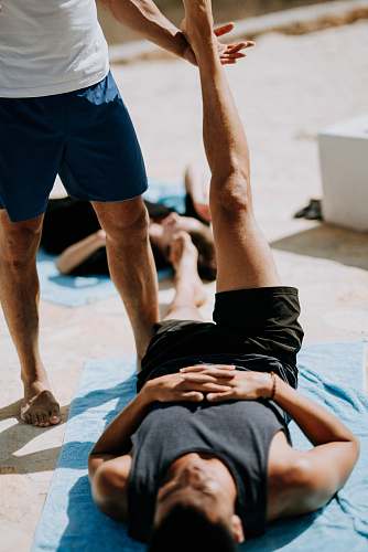 person man lying on floor near man standing holding his leg people