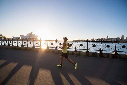 person man running on bay walk during daytime tarmac