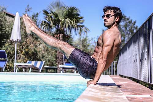 person man sitting beside pool people