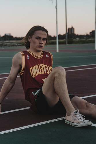 person man sitting on field apparel