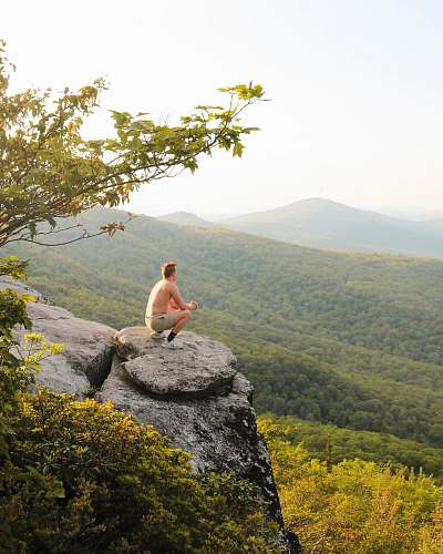 person man sitting on rock boulder adventure