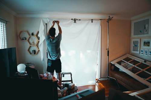 person man standing beside white curtain exercise