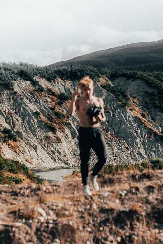 person man standing near mountain range outdoors