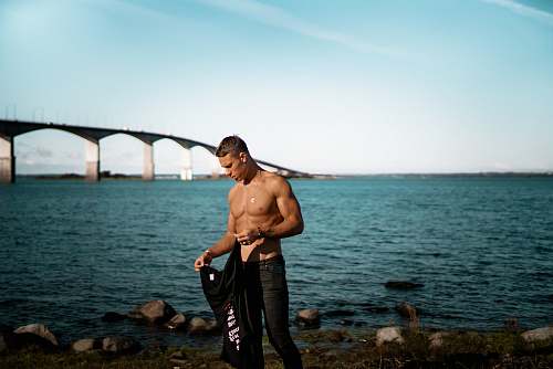 person man standing near the shore in shallow photo people