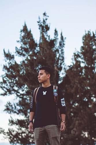 person man standing near tree apparel