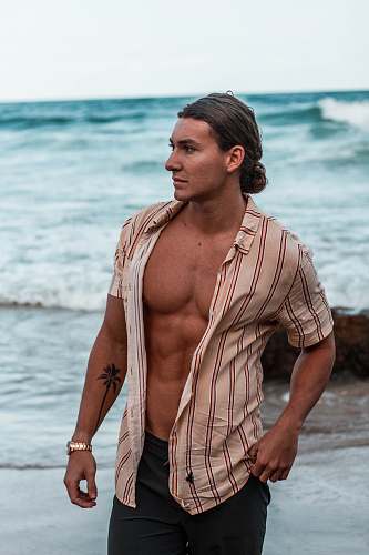 person man standing on seashore during daytime man