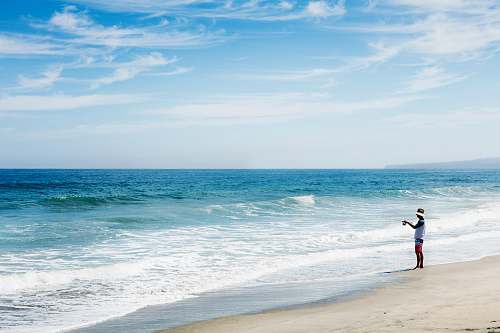 person man standing on shore water