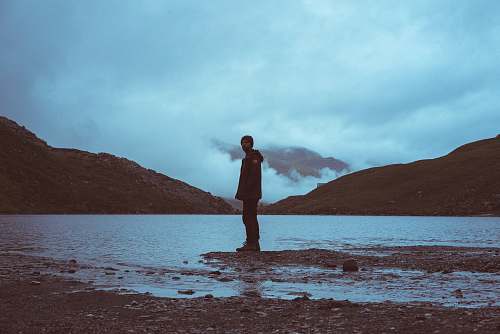 person man standing on shoreline people