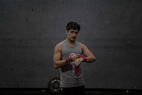 person man standing wearing gray tank top sports