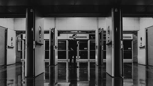 black-and-white man walking beside glass panels flooring