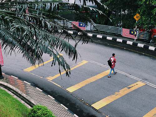 asphalt man walking on concrete road during daytime tarmac