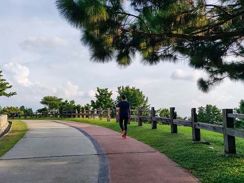 person man walking under white clouds during daytime exercise