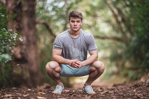 person man wearing gray crew-neck t-shirt and shorts during daytime sport