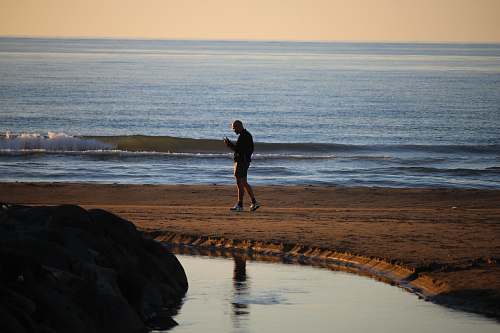 person man wearing short standing on shore nature