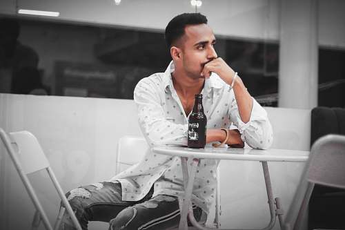 person men's white and gray button-up long-sleeved shirt sitting