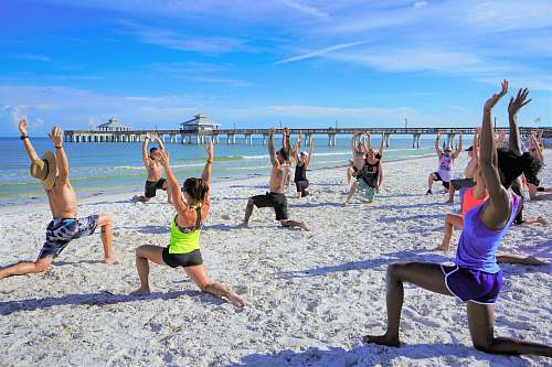 person people exercising on seashore during daytime sports