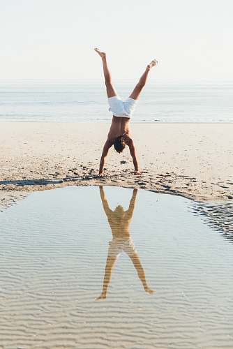 person person doing cartwheel on seashore people