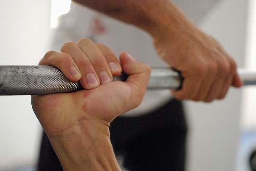person person holding barbell bar finger