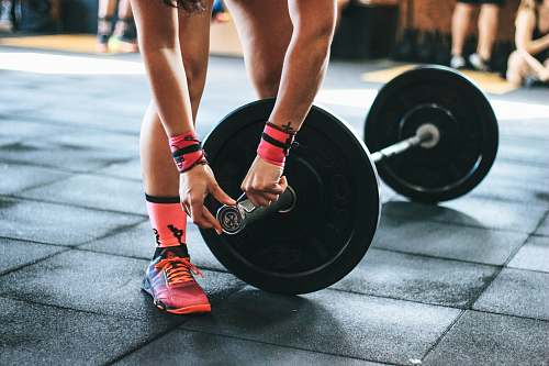 person person locking gym plates on barbell people