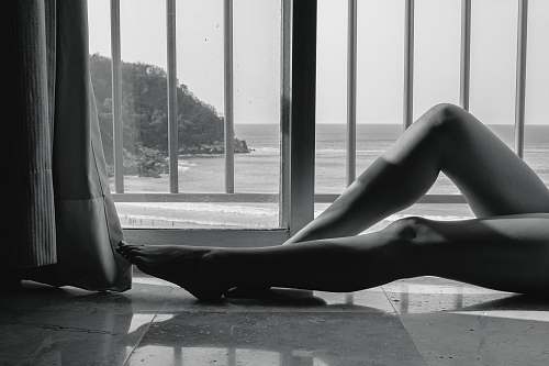 black-and-white person lying beside rails grey