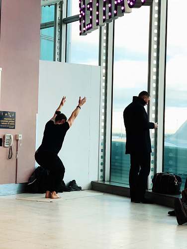 people person squatting while raising his both arms upward in building person