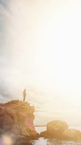 outdoors person standing on rock near ocean nature