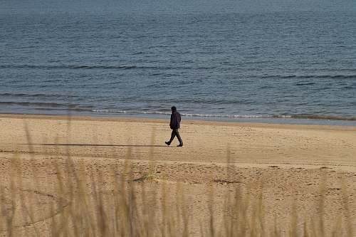 person person walking near beach line sand