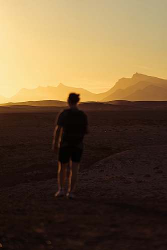 person person walking on desert during golden hour people