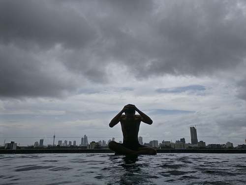 grey photography of man on body of water under cloudy sky during daytime water