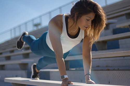 person selective focus photography of woman doing planking on bench handrail