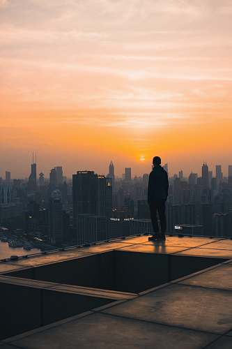 person silhouette of person looking at city buildings during daytime nature