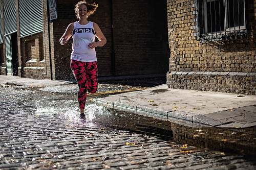 path smiling woman running in road with water walkway