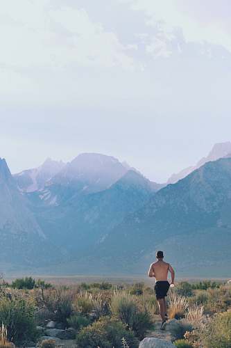 person topless man jogging in green field skin