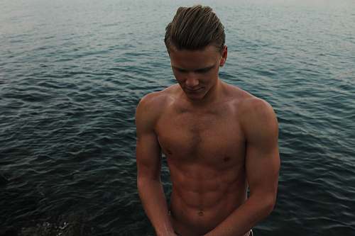 person topless man looking down with ocean background people