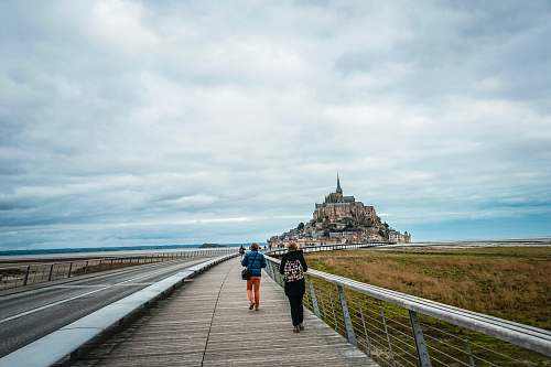 person two person walking on pathway near road boardwalk