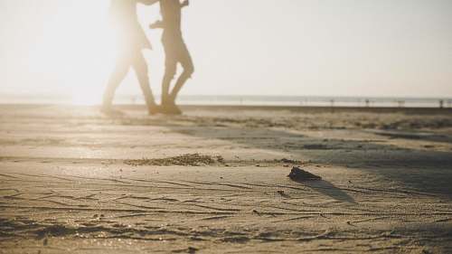 person two person walking on sand during daytime exercise