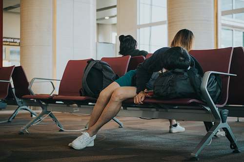 person unknown person lying on brown bench indoors apparel