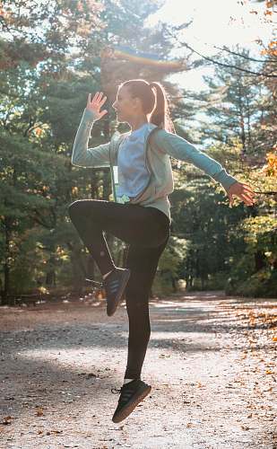 person woman dancing near trees woman