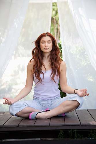 person woman doing yoga pose sitting on wooden ground working out