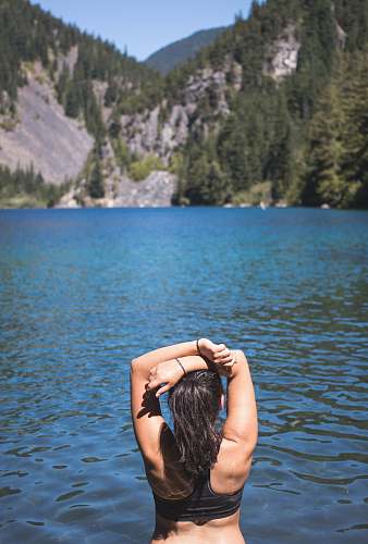person woman facing mountain with pine trees people